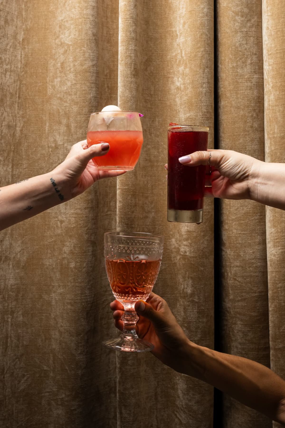 Toasting with cocktails in front of Alura's curtains