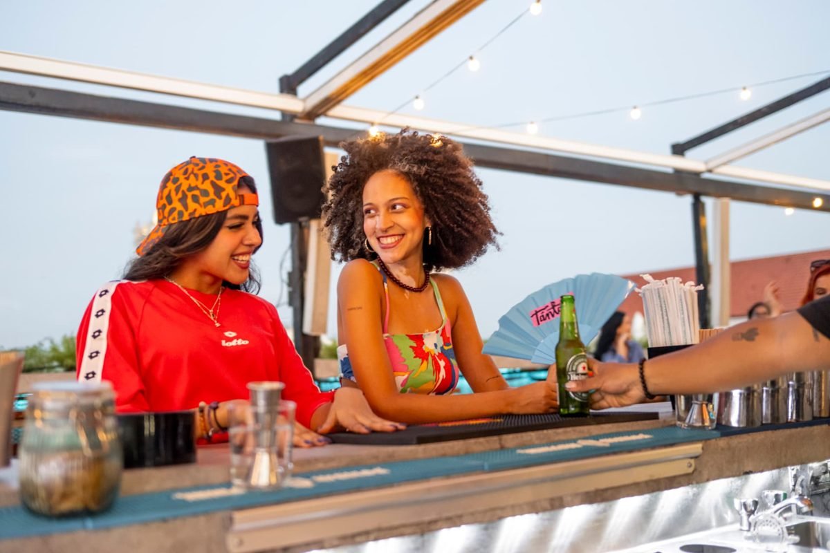 Dos mujeres conversando en la barra del rooftop de Tántalo