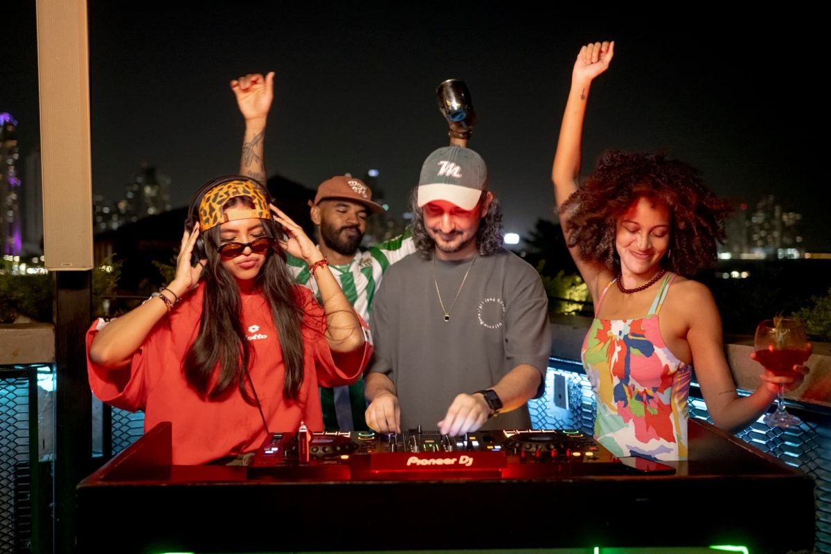 DJ tocando y personas celebrando de noche en el rooftop de Tántalo