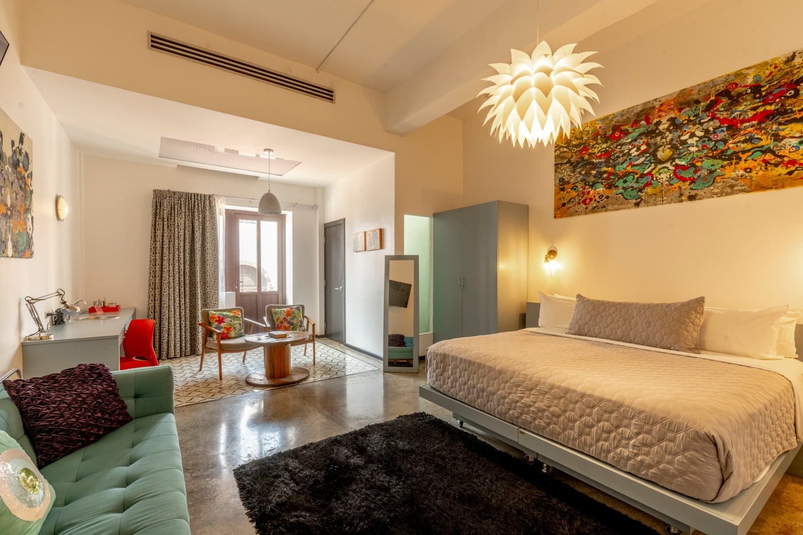 Double Double room with turquoise sofa and king bed, by artist Cris Allende